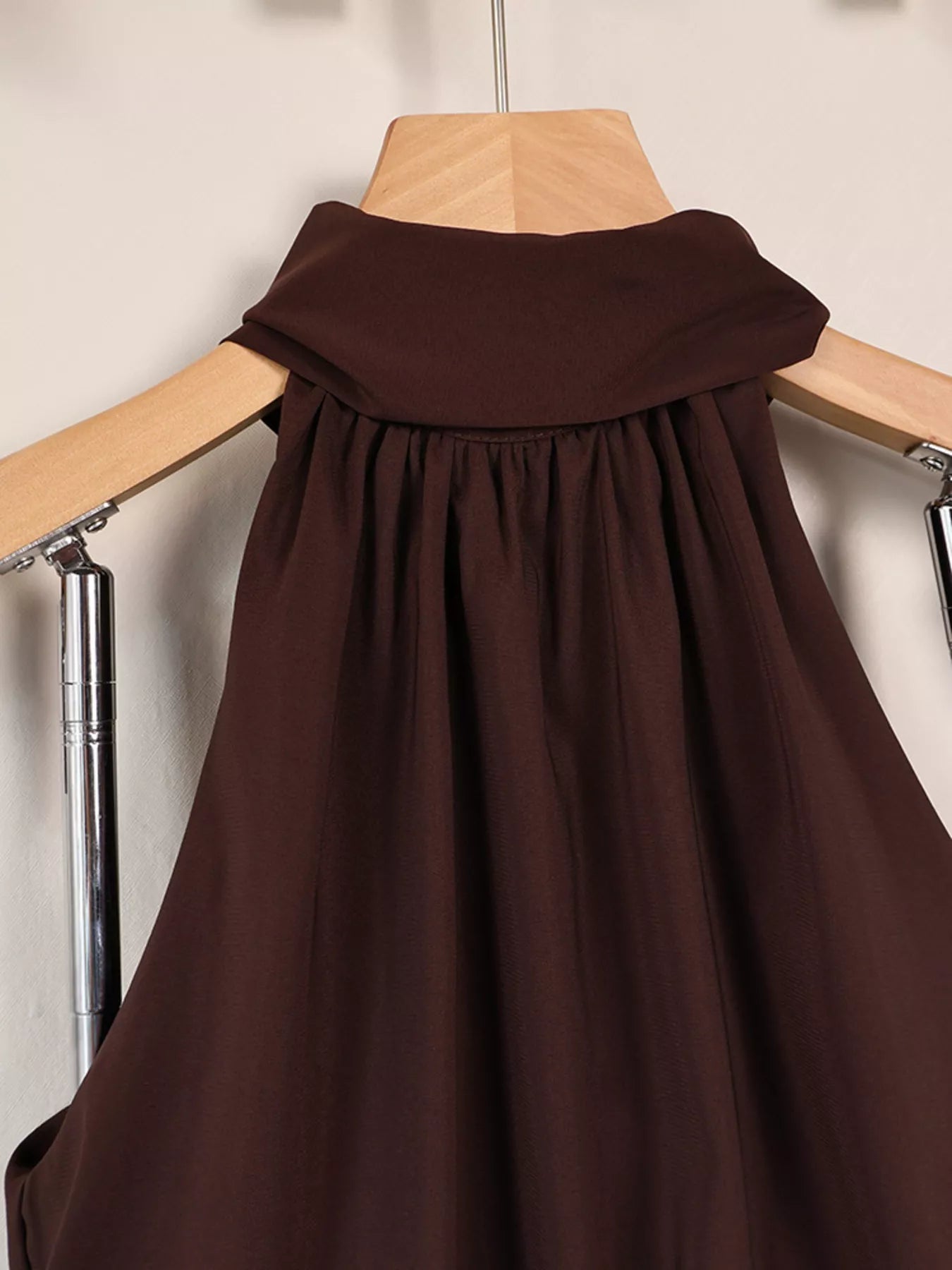 Brown halter mini dress on hanger, close front view of gathered bodice