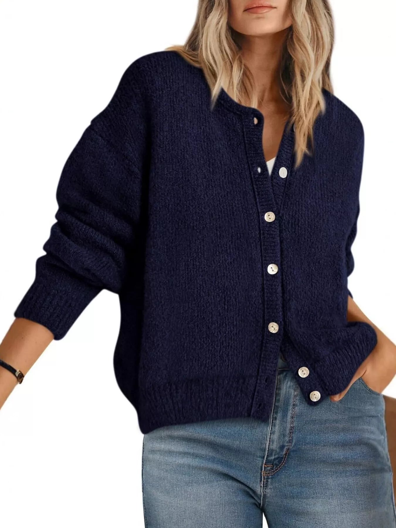 Front view of navy button down cardigan with white buttons worn with blue jeans