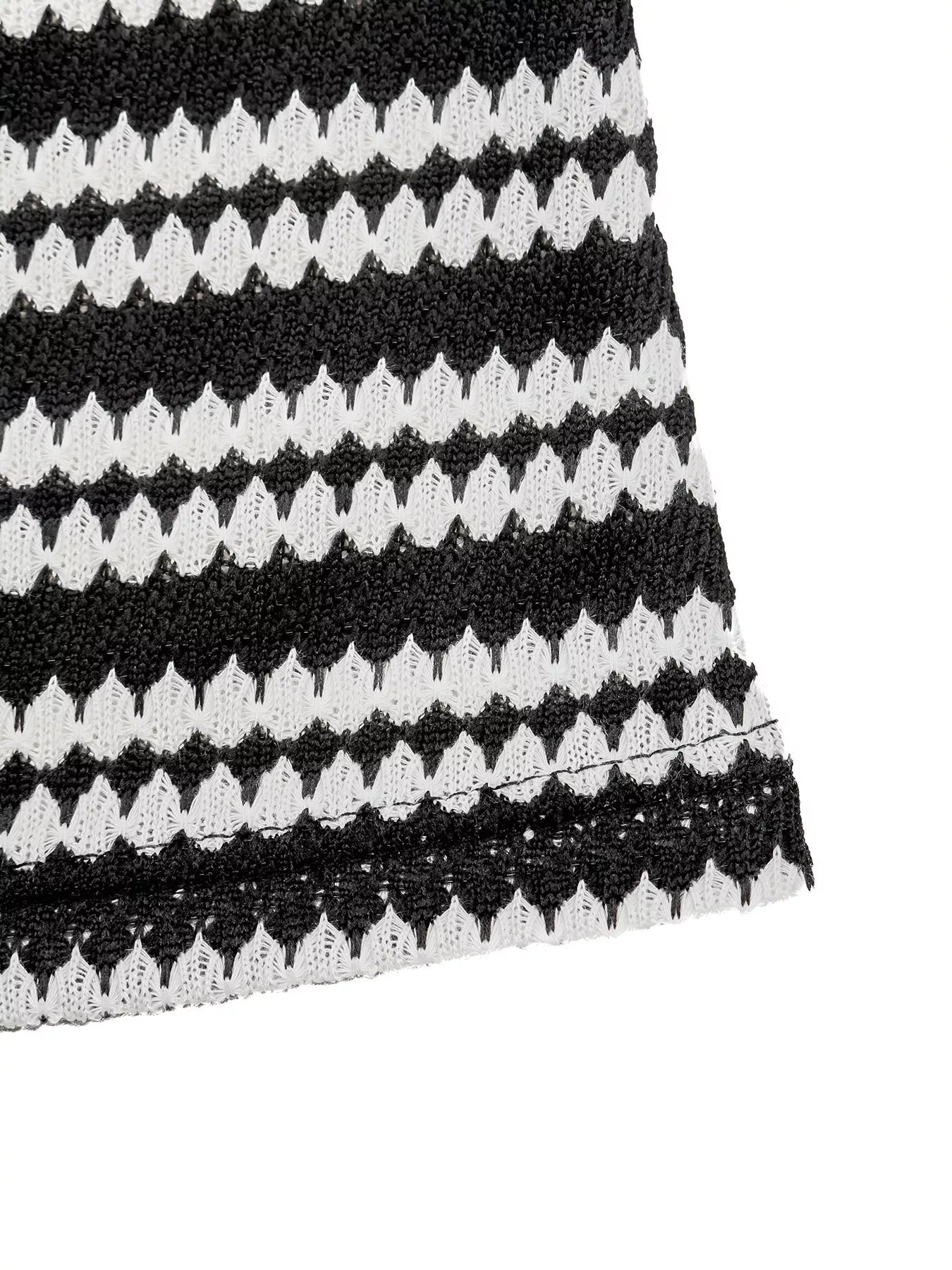 Close up flat detail of a black and white striped knit dress hem