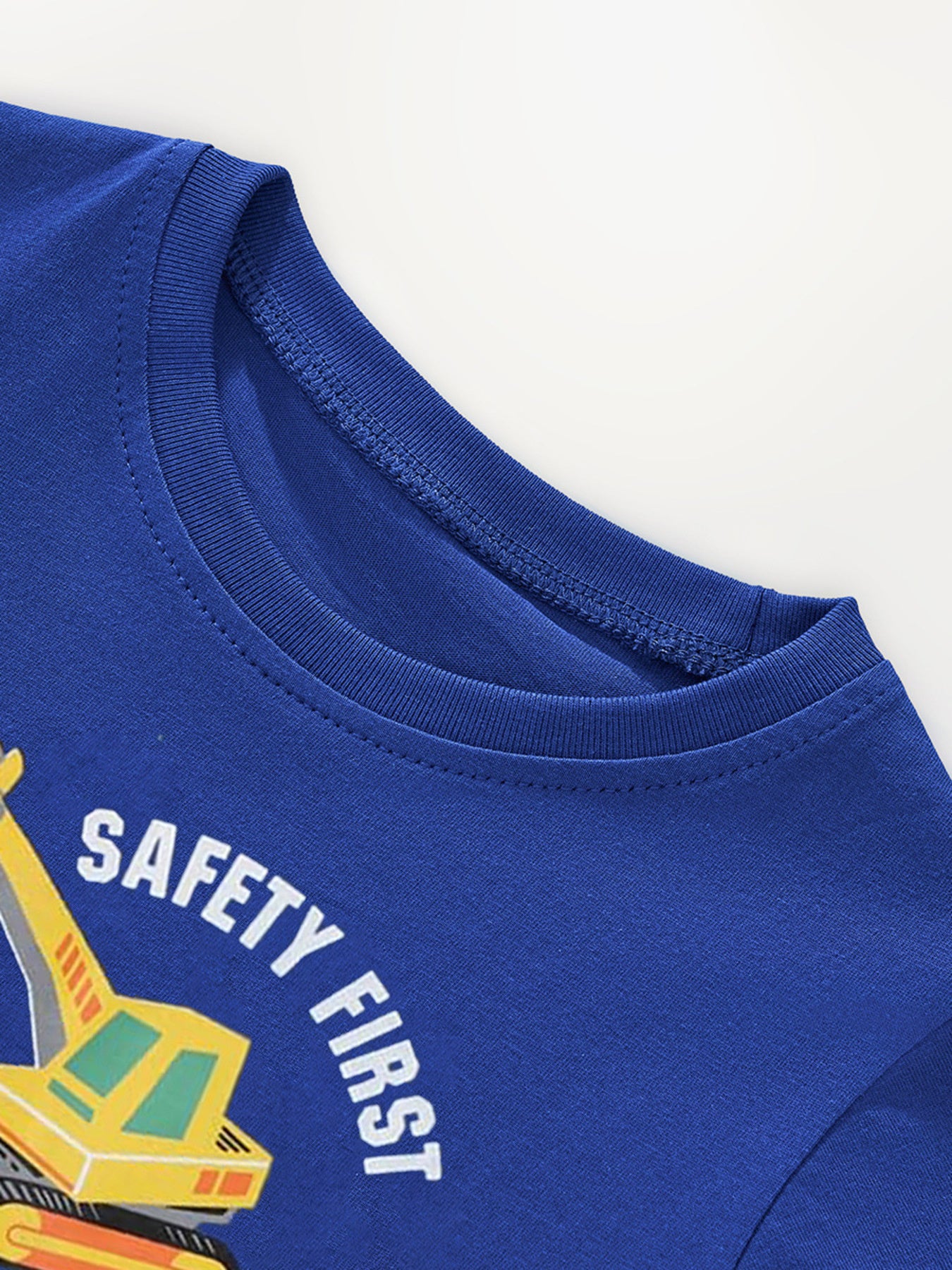 Close-up of the ribbed crew neckline on the navy children's construction vehicle tee