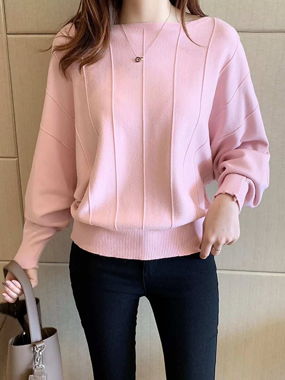 Front view of a blush pink batwing sleeve knit top with vertical seams and ribbed hem.