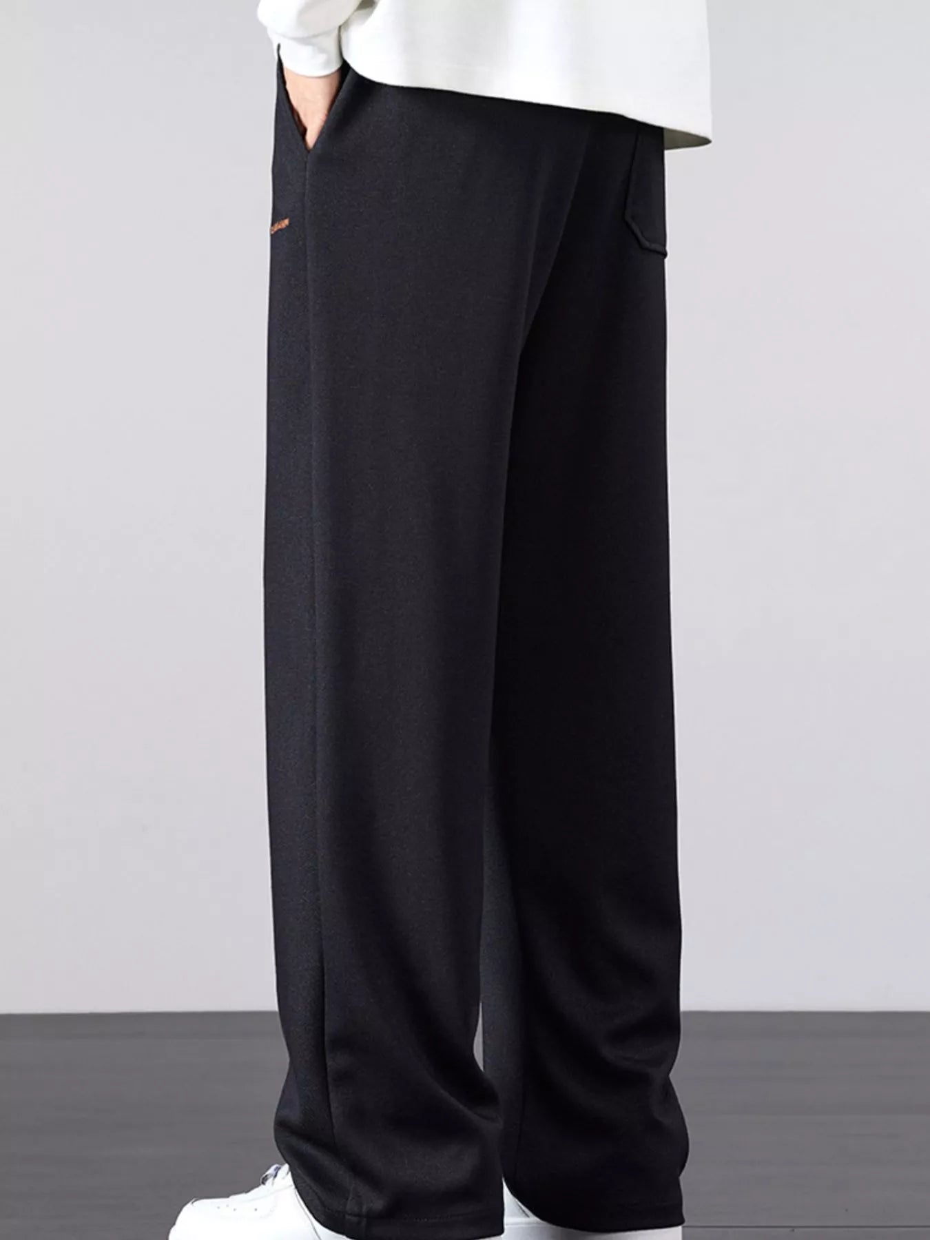 Men's loose fit casual pants with a drawstring waist and pockets.