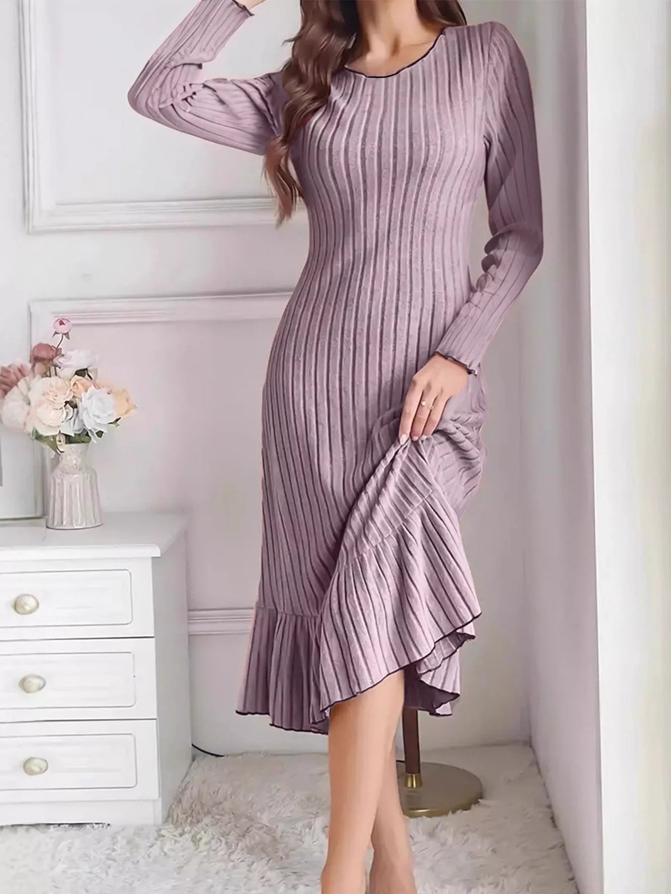 Light purple ribbed knit bodycon dress with ruffle hem worn indoors, front view lifting the skirt