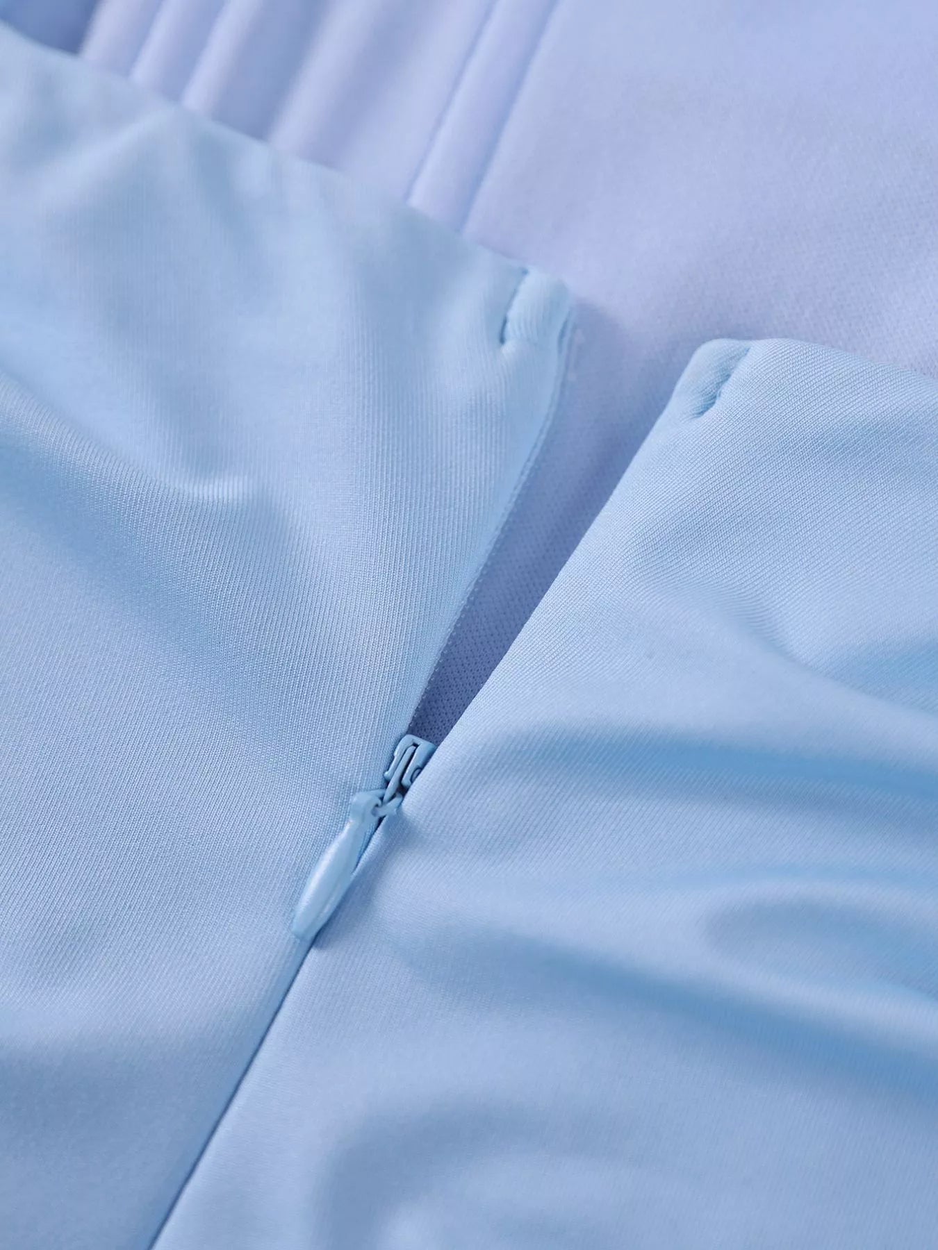 Close view of the light blue back zip on a ruched spaghetti strap bodycon maxi dress