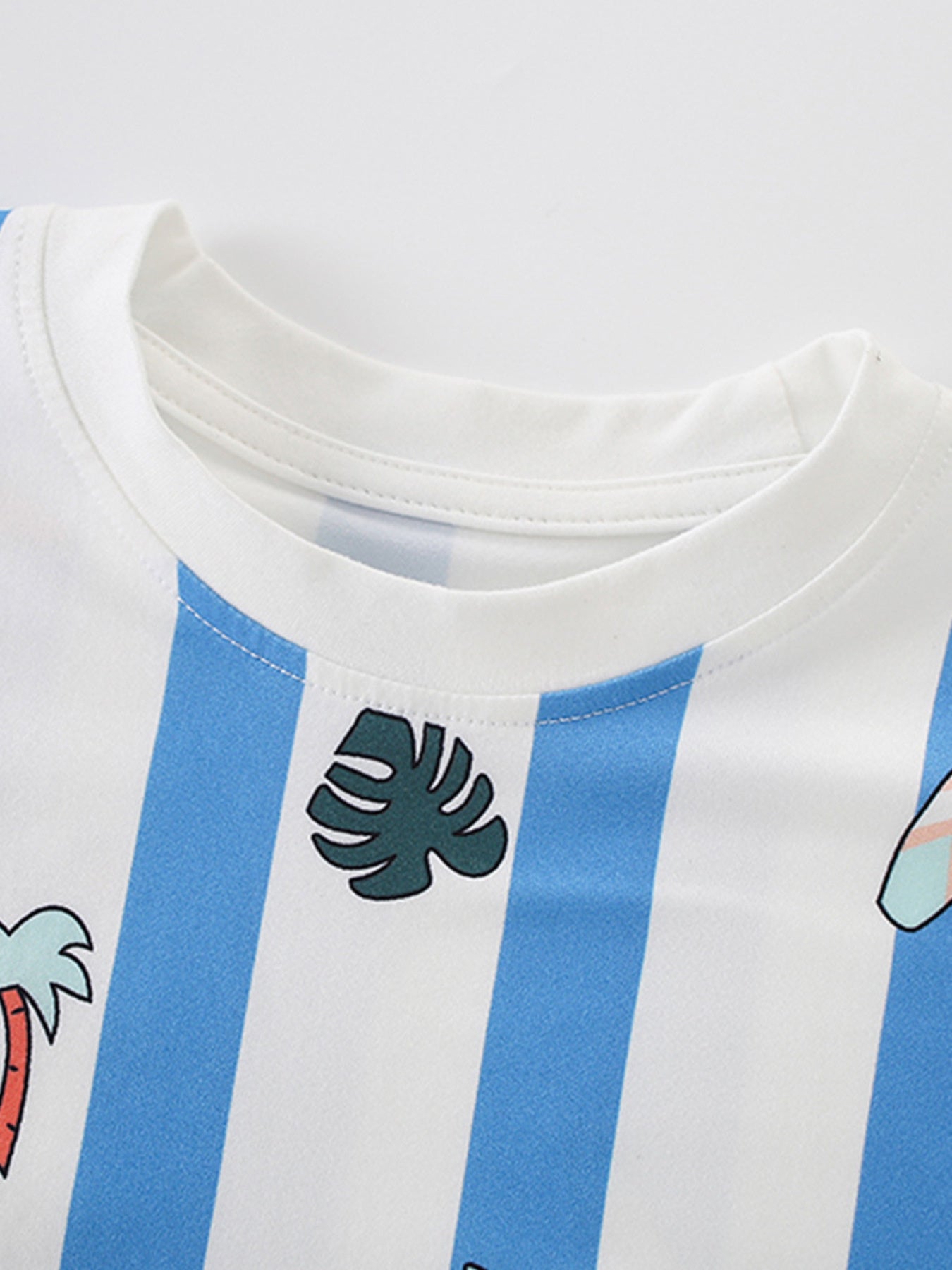Close up of the white round neckline on a blue and white striped children's cartoon tee