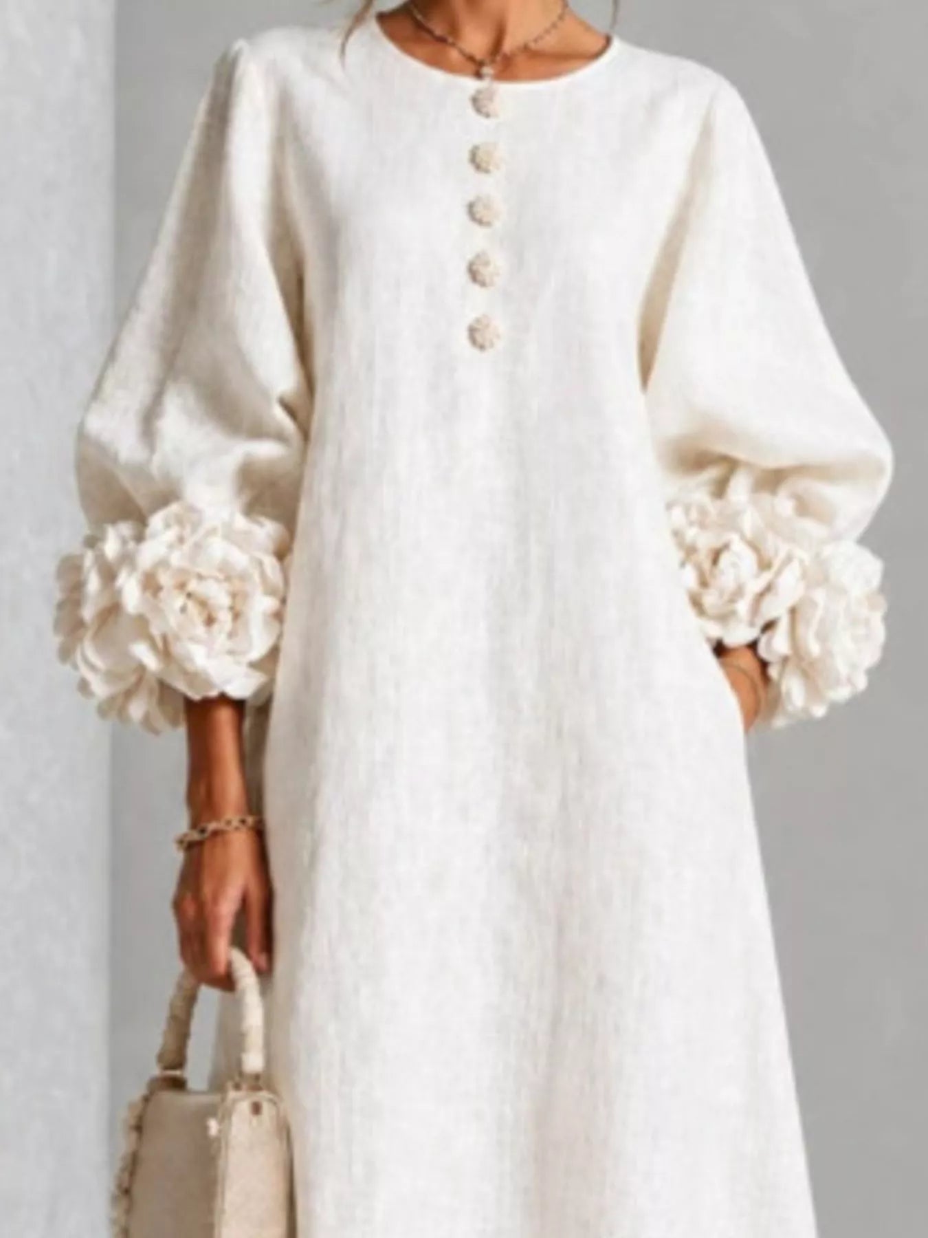 Close front view of the white round neck midi dress bodice with small floral buttons and floral cuffs