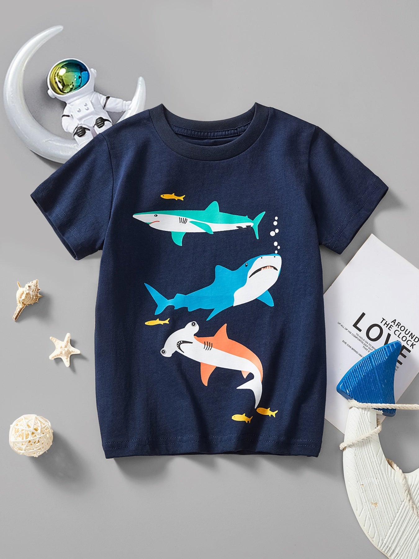 Dark navy children's short sleeve t-shirt laid flat with colorful shark and small fish print
