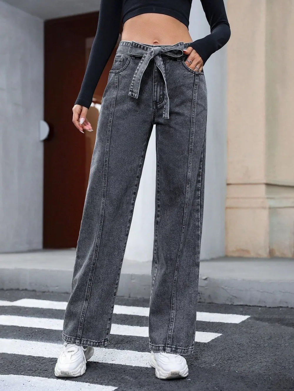 Women's dark gray straight-leg jeans with tie details and pockets.