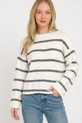 Front view of white striped sweater with charcoal horizontal stripes and jeans