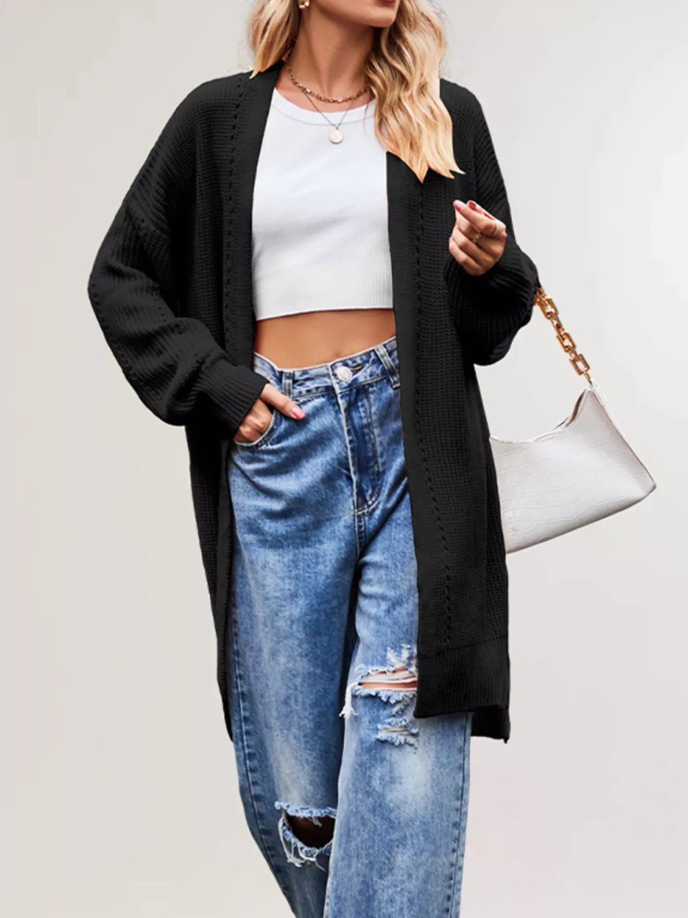 Black long open front cardigan with openwork stripes worn over jeans