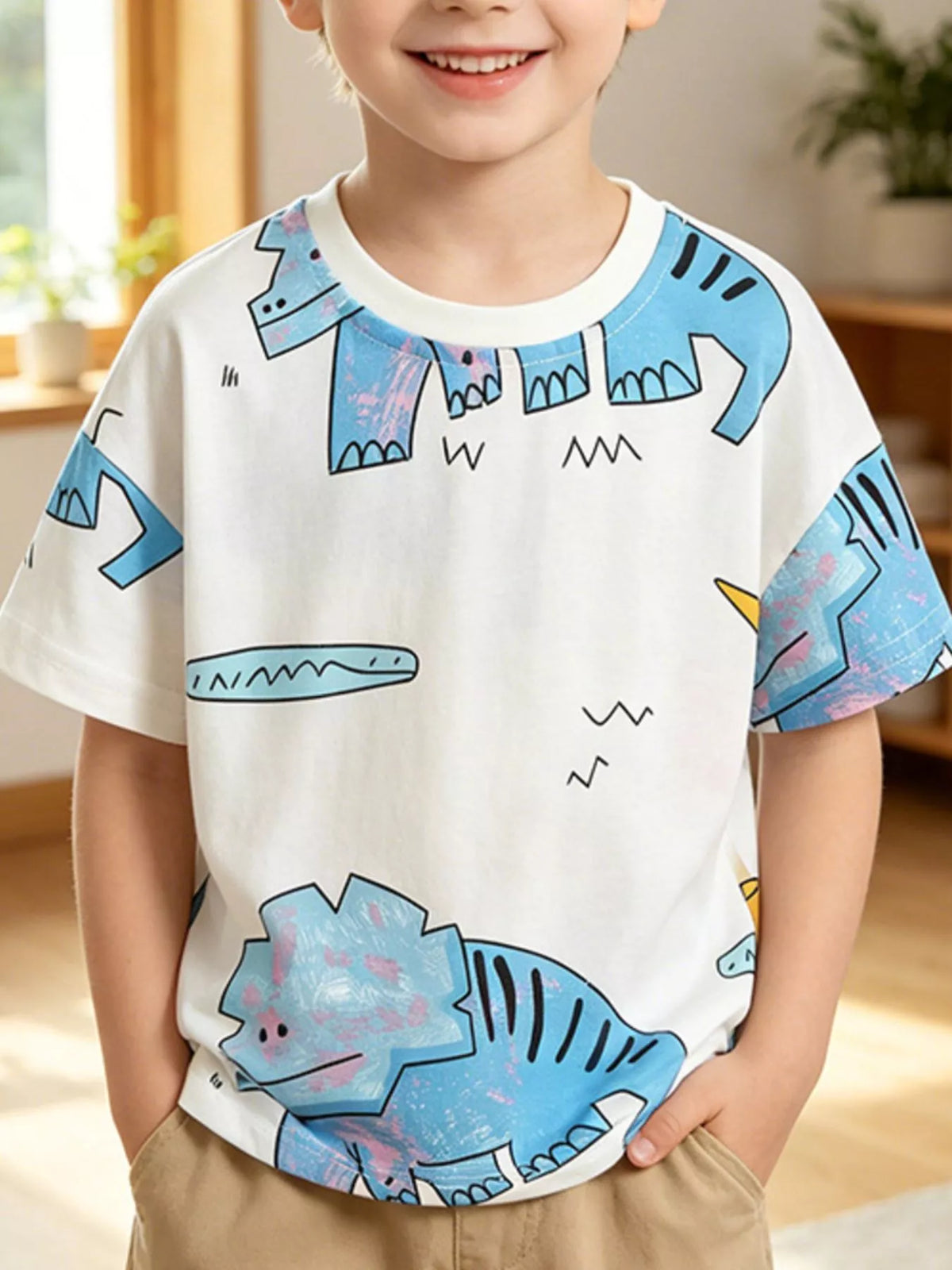 Front view of a white children's tee with large light blue cartoon dinosaur prints
