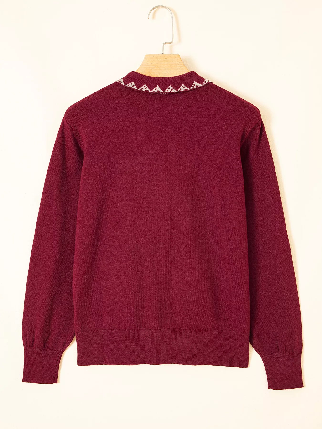 Back view of the burgundy knit cardigan on a hanger showing collar trim
