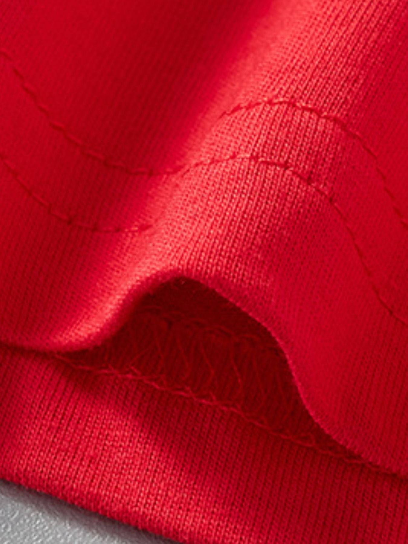 Close-up detail of the red hem stitching and fabric on children's rocket T-shirt