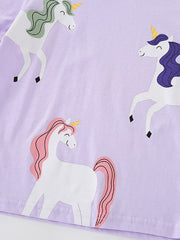 Close view of the three white unicorn graphics with colorful manes on the light purple T-shirt
