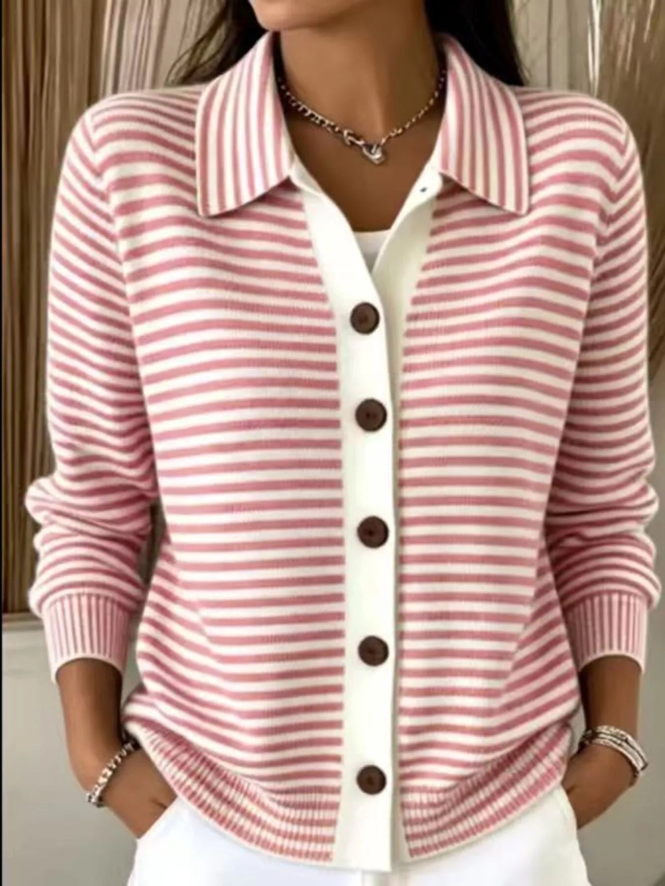 On-model front view of pink and white striped collared cardigan with brown buttons
