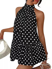 Black polka dot halter neck mini dress shown front on against a white background