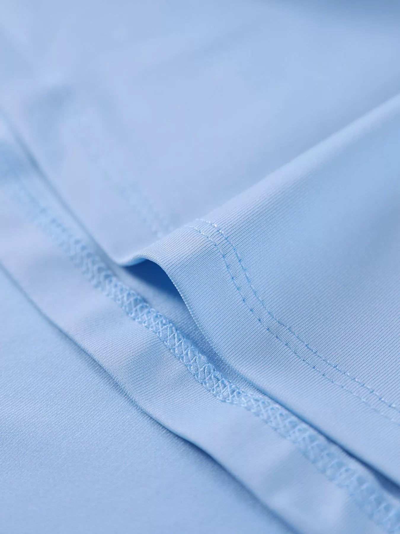 Close view of light blue hem stitching on a ruched spaghetti strap bodycon maxi dress