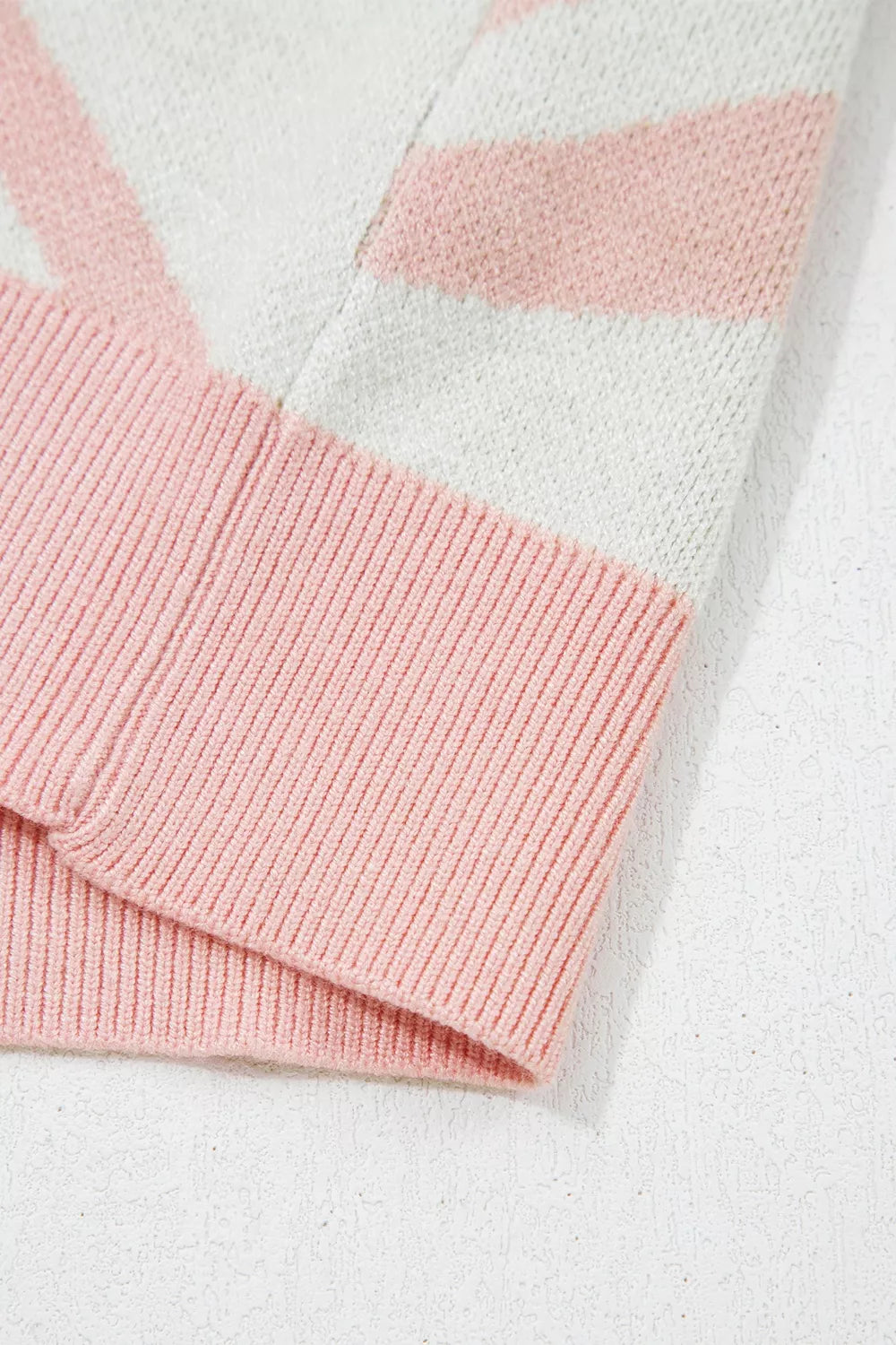 Close-up of the pink ribbed hem on the cream cactus sweater vest