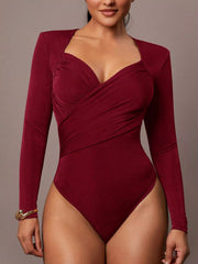 Model wearing burgundy ruched surplice long sleeve bodysuit in front view