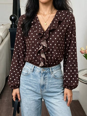 Indoor front view of a coffee brown polka dot bodysuit with a ruffled V neckline and long sleeves