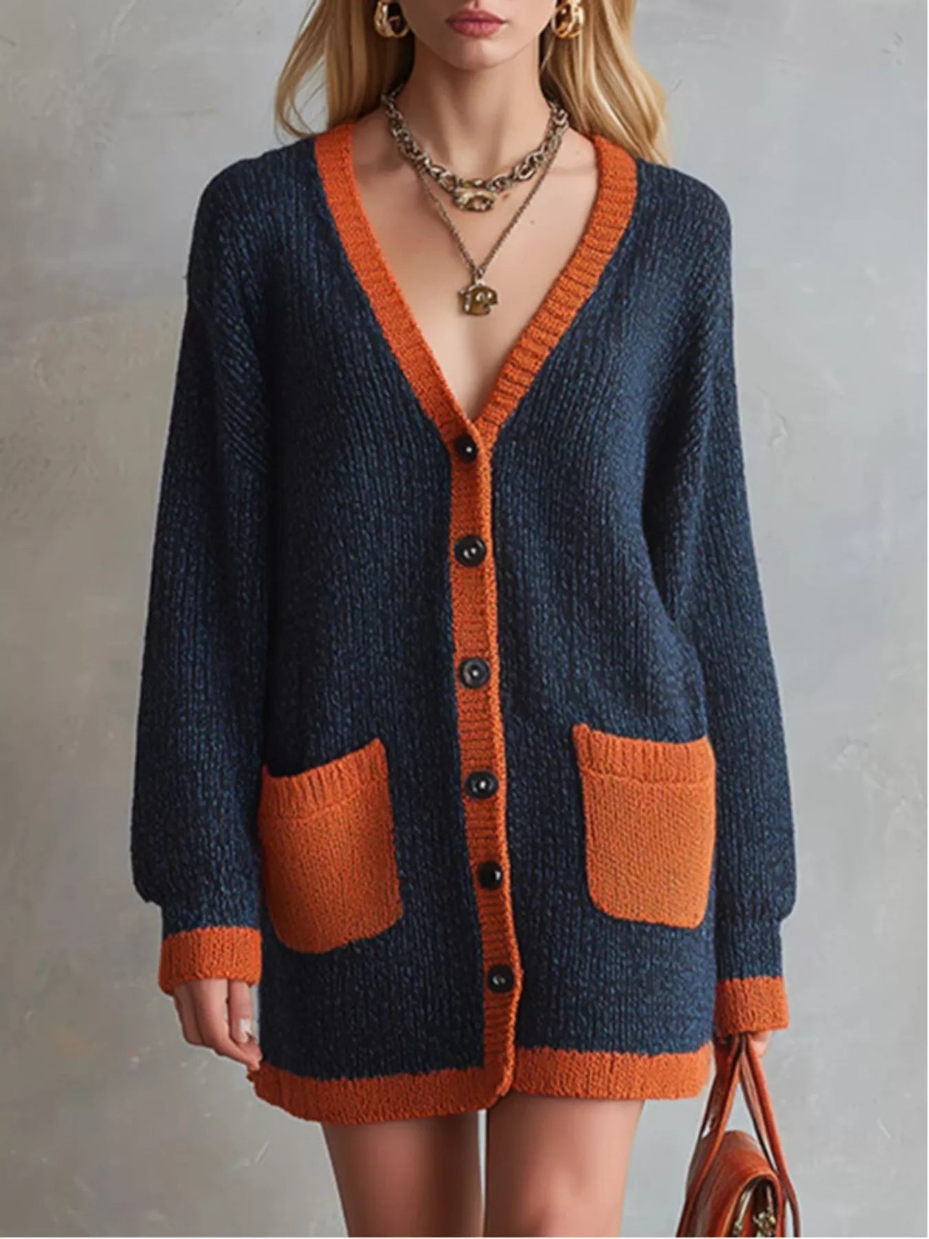 Close up of the navy V neck cardigan showing its orange trim and dark buttons