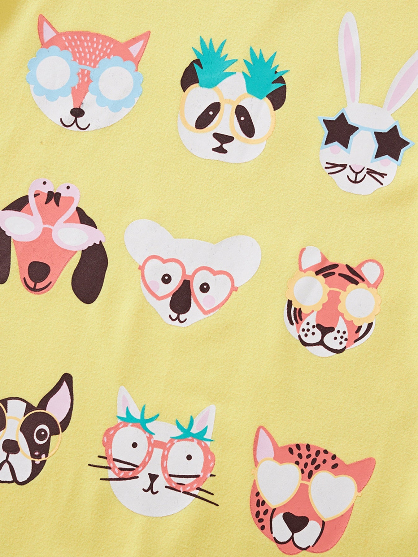 Close view of the cartoon animal faces graphic on the yellow children's t-shirt