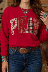 Scarlet western sweatshirt with patchwork PRAY lettering worn with jeans, front view