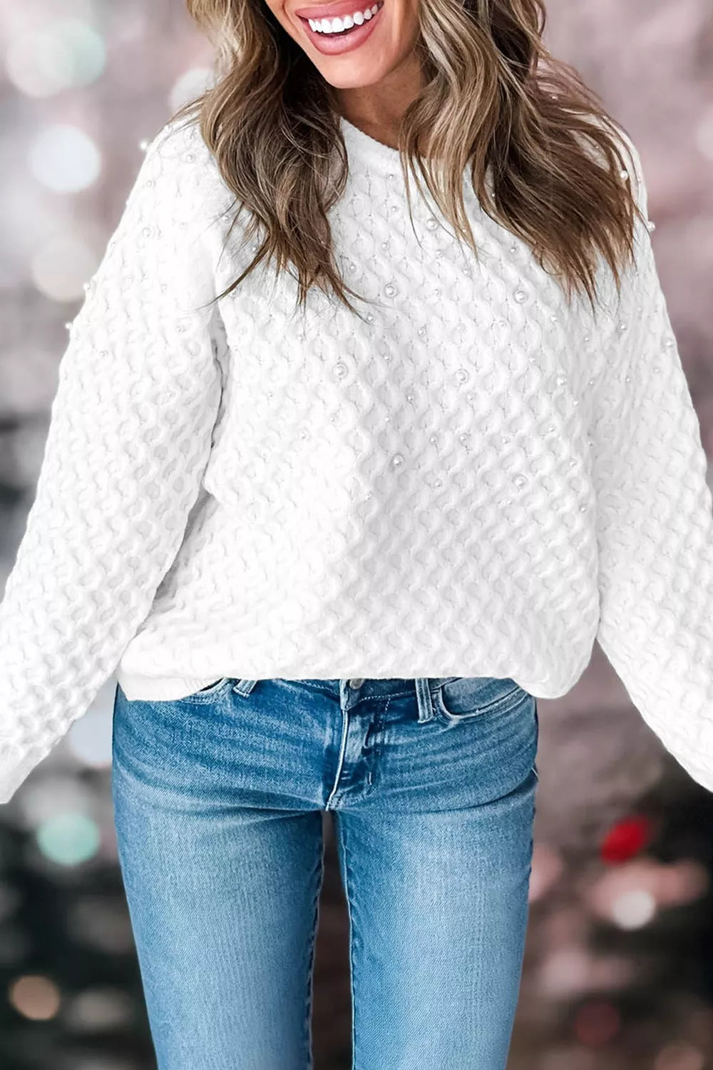 On-model front view of white pearl embellished textured knit pullover sweater against blurred background