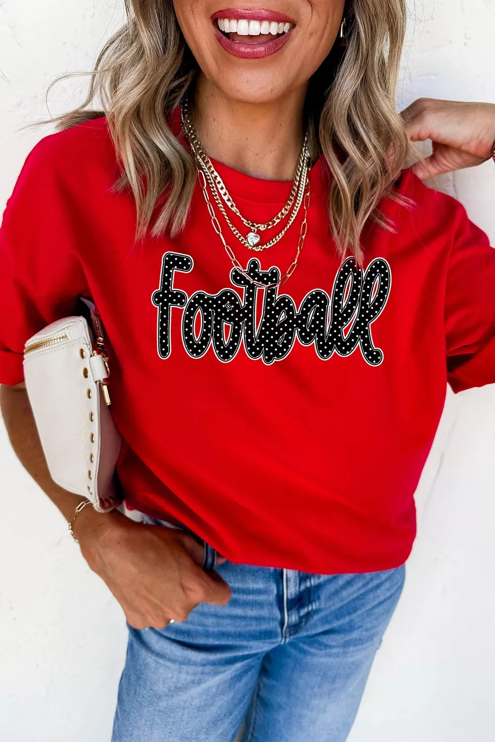 Front view of deep red game day t shirt with polka dot Football lettering worn with jeans