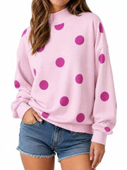 Front view of pink mock neck oversized sweatshirt with large magenta polka dots on model