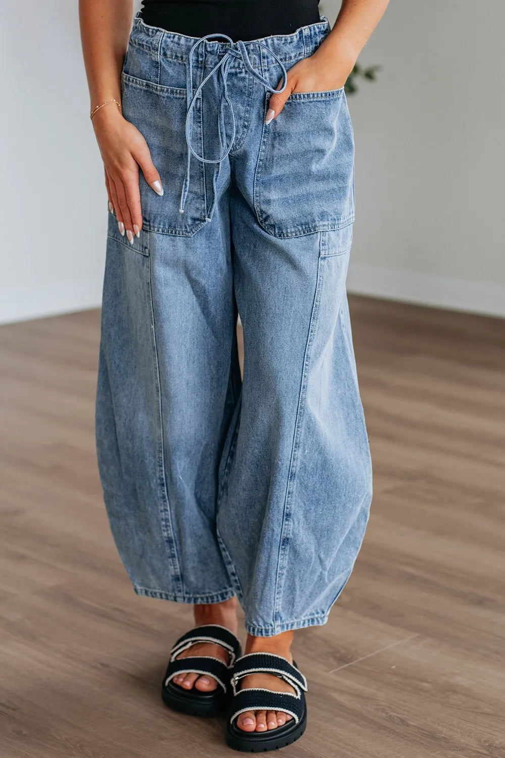 Women's wide-leg jeans with a drawstring waistband and pockets.