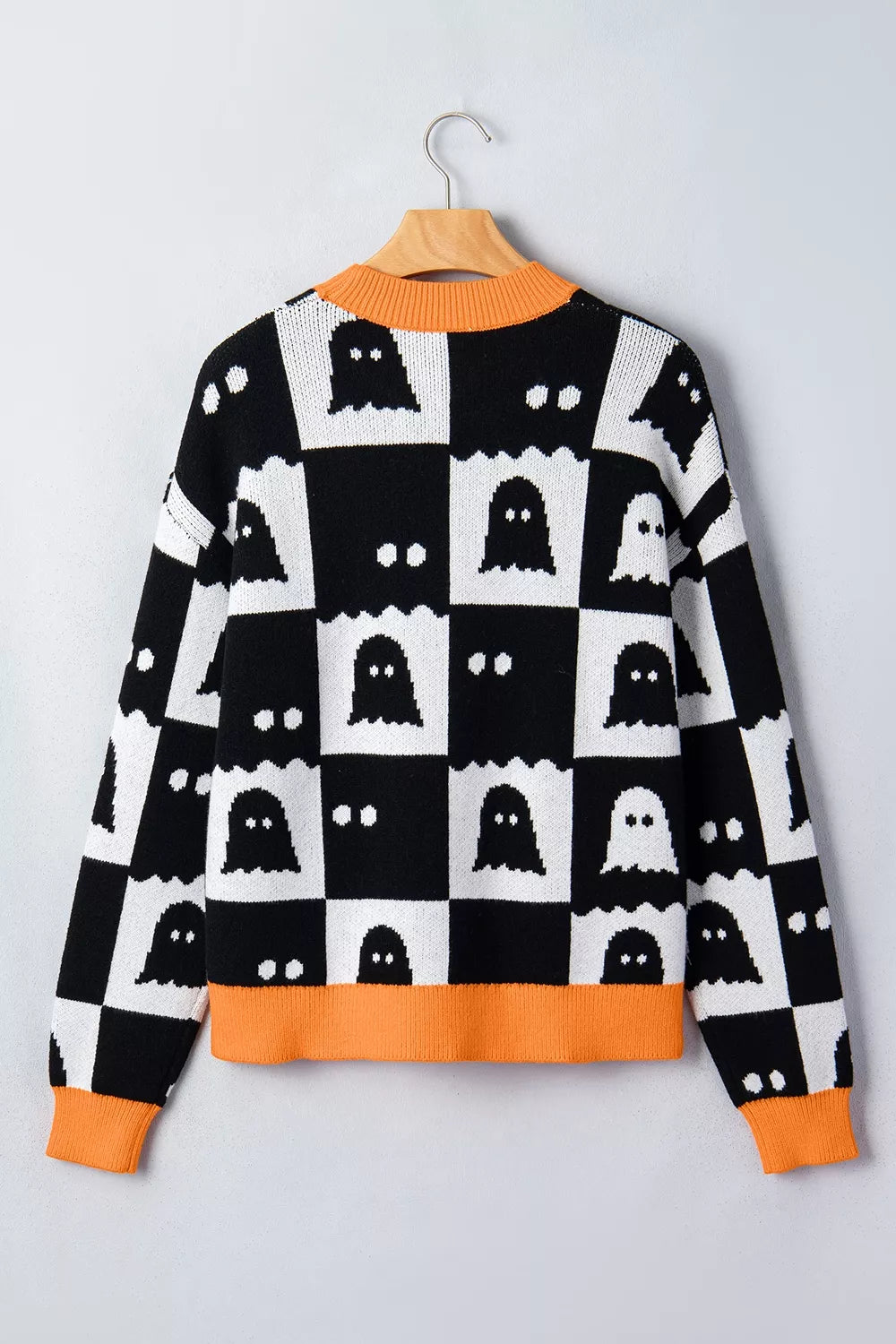 Flat back view on a hanger of a black and white ghost checkerboard sweater