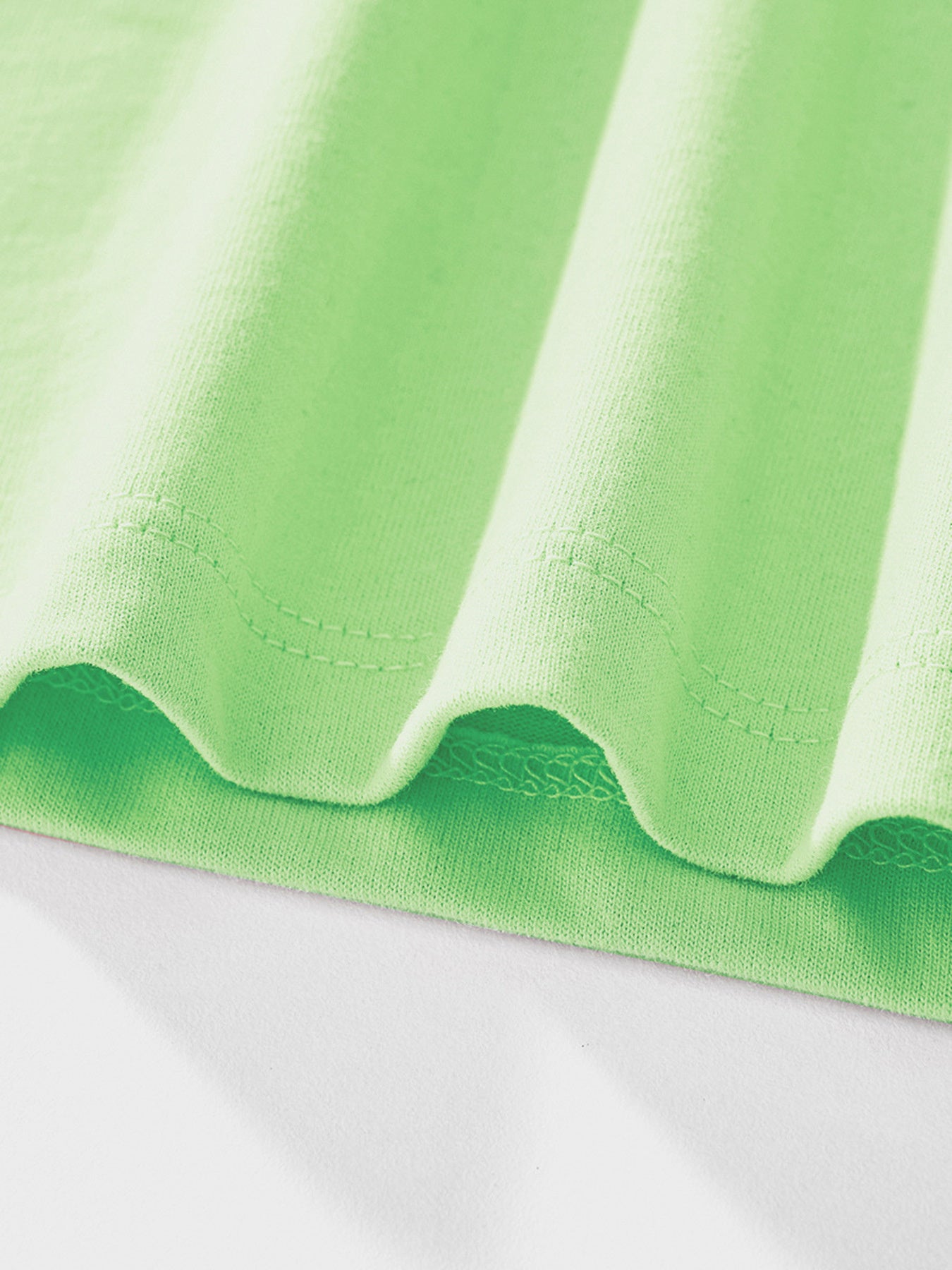 Close-up detail of the light green hem stitching and fabric on children's bunny tee