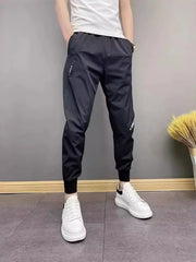 Men's black slim-fit ankle-cuffed pants with a drawstring waist and pockets.