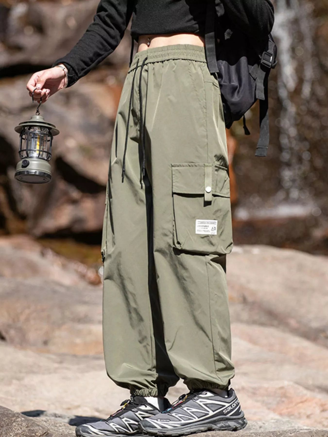 Men's military green loose-fit cargo pants with a drawstring waist and pockets.
