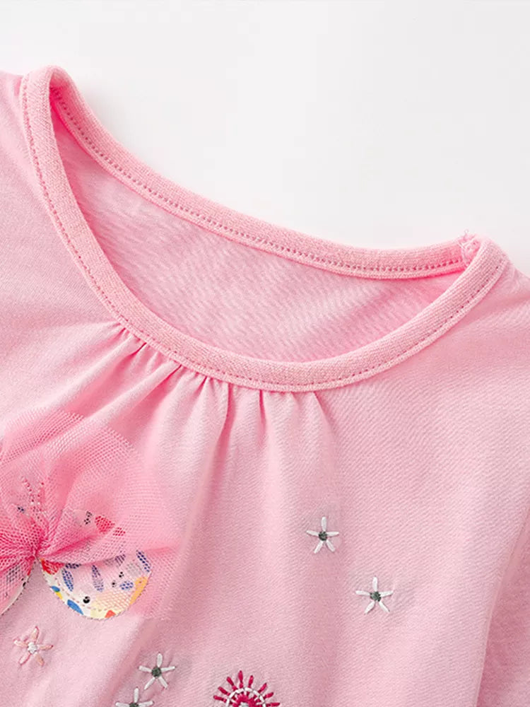 Detail view of the gathered round neckline and small embroidered stars on a children's blush pink t-shirt