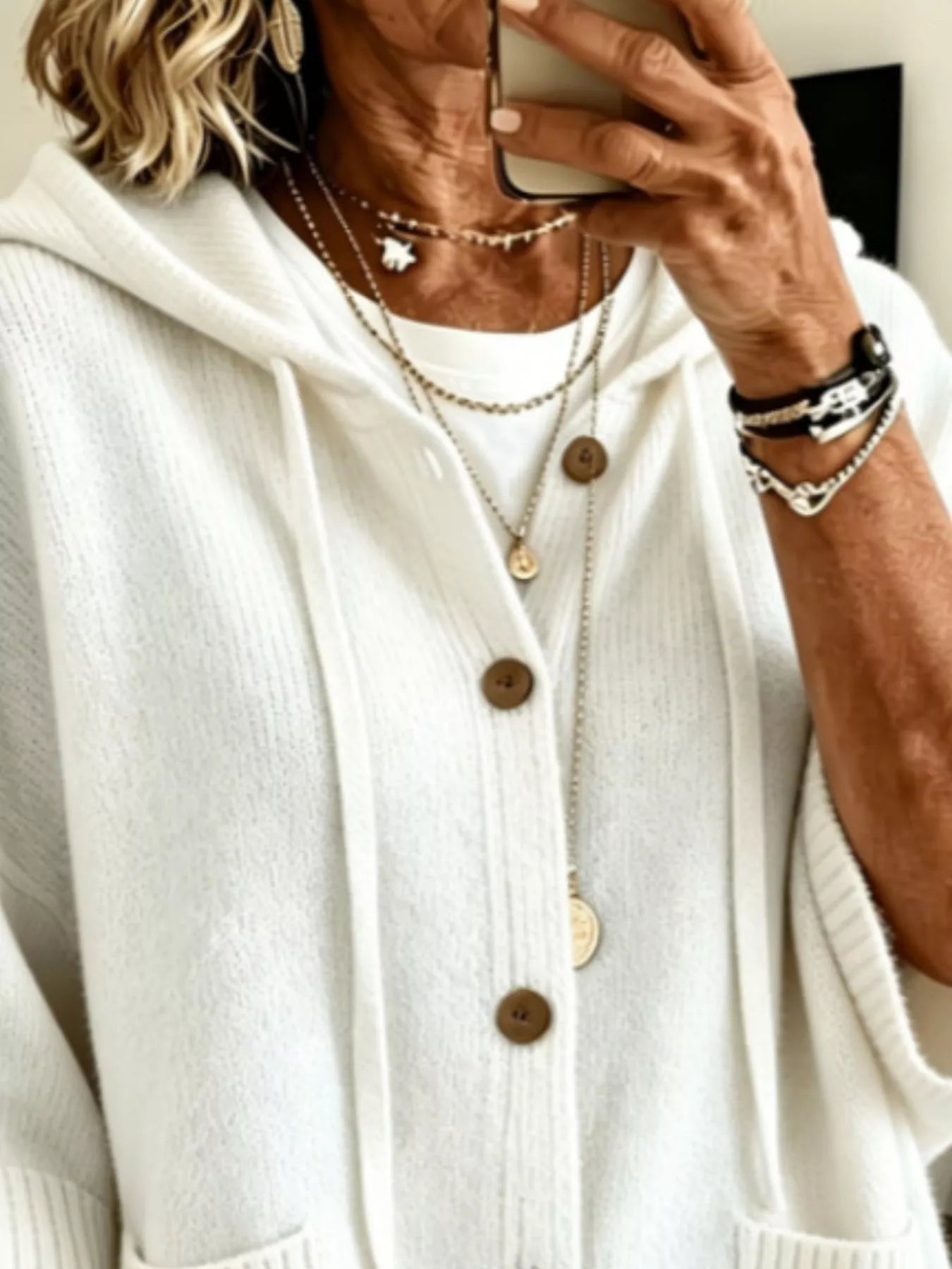 Close view of the white hooded cardigan showing drawstrings and button front