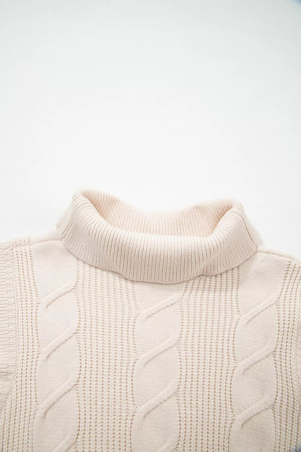 Close-up of the cream cable knit turtleneck sweater front neckline