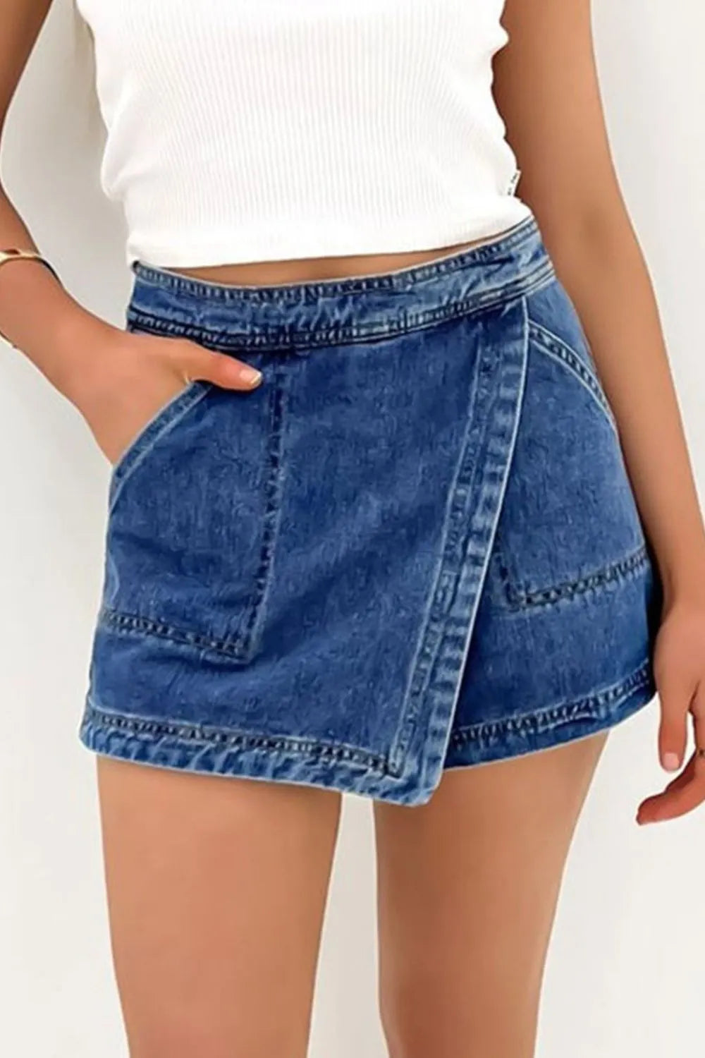 Women's denim skort featuring an asymmetrical design and pocket detailing.