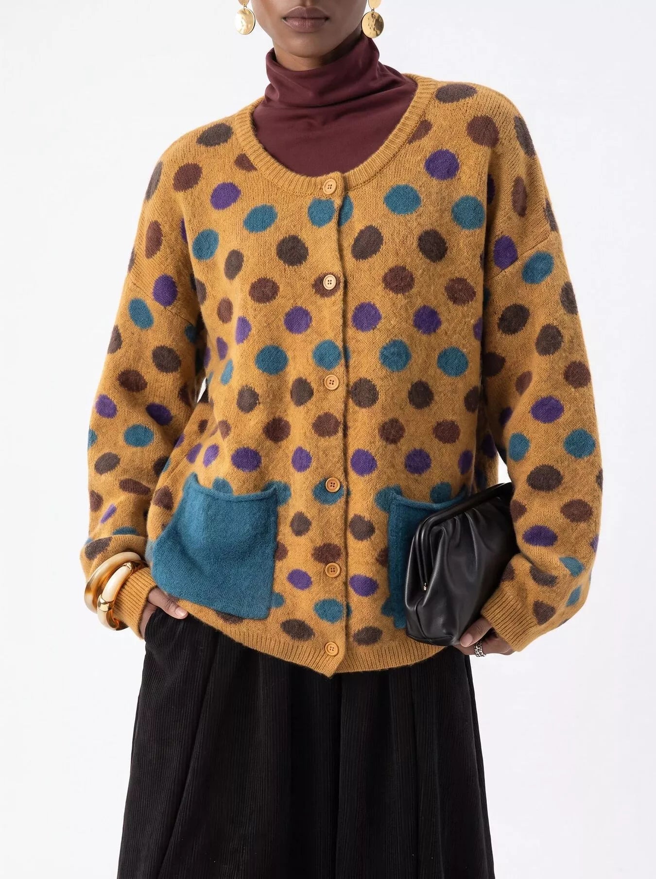 Mustard polka dot cardigan with buttons and teal pockets on model