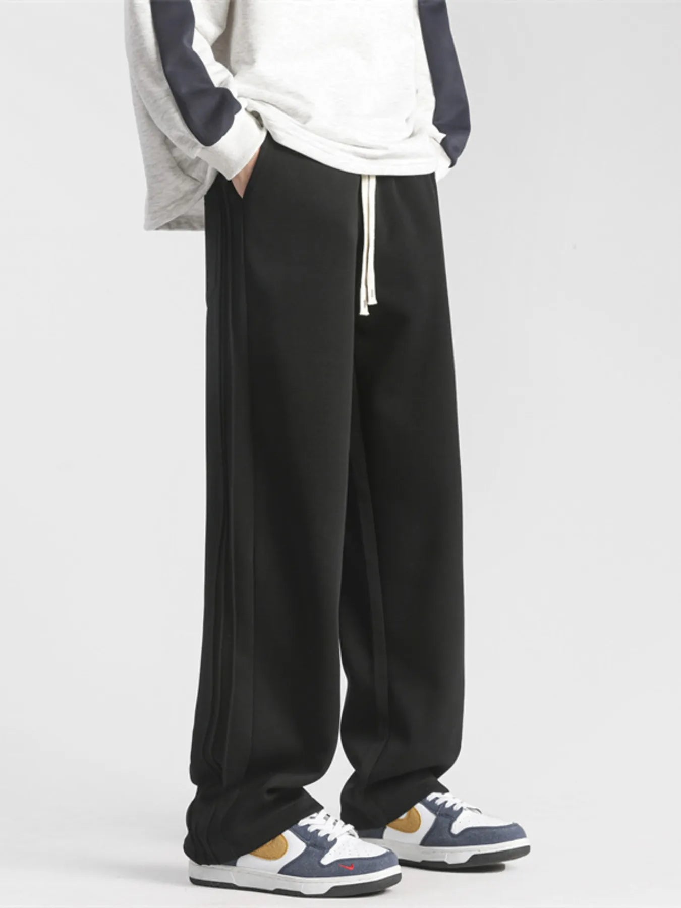 Men's black loose-fit sweatpants with a drawstring waist and pockets.