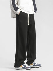 Men's black loose-fit sweatpants with a drawstring waist and pockets.