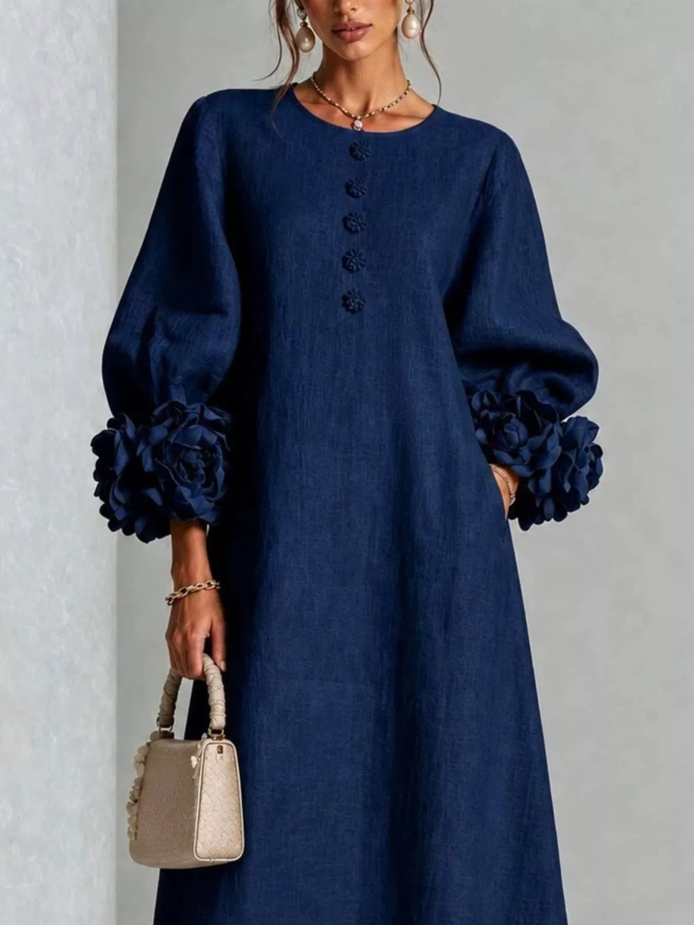 Close front view of the navy round neck midi dress bodice with small floral buttons and floral cuffs