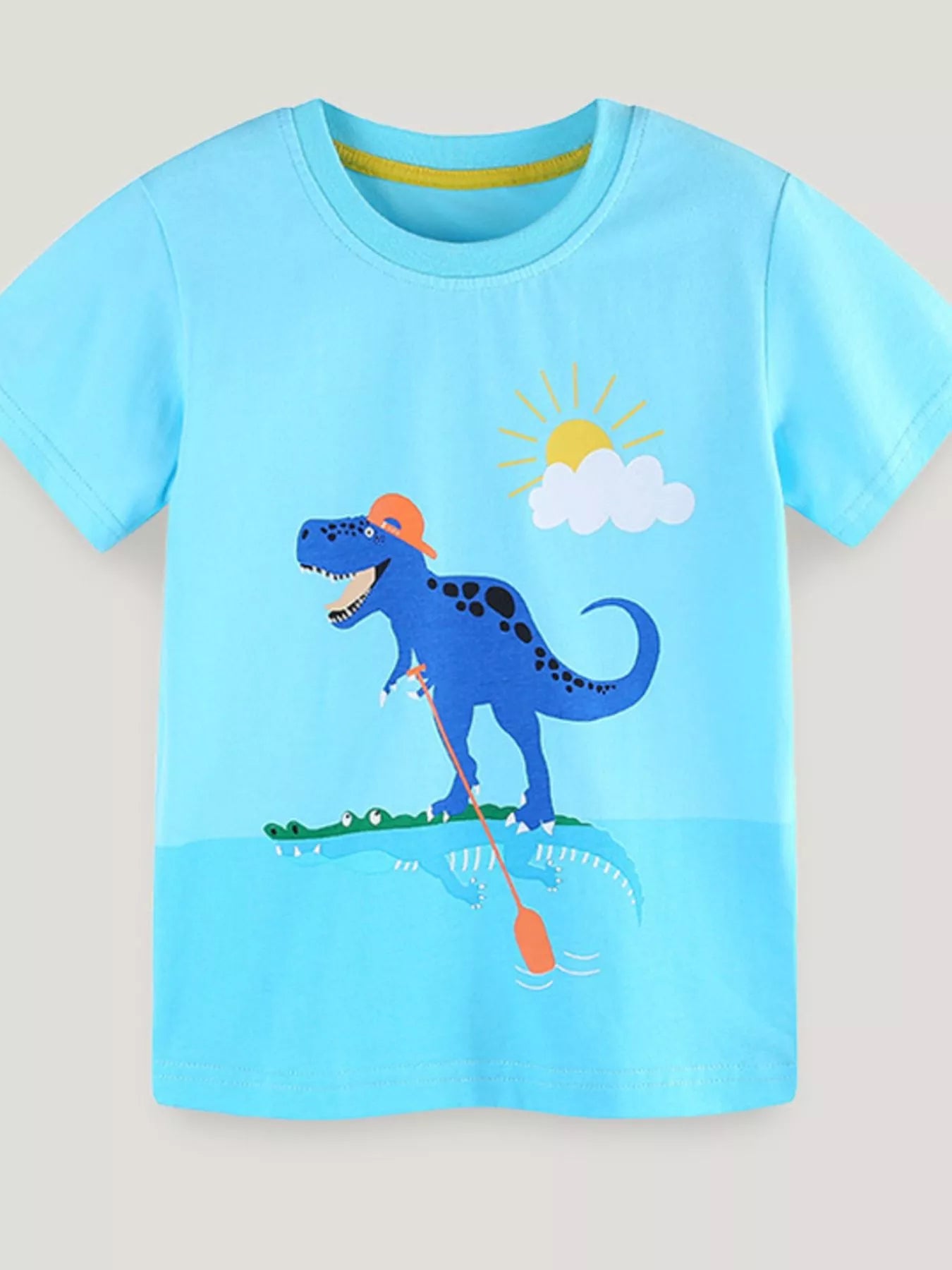 Children's pastel blue short-sleeve T-shirt featuring a dinosaur graphic.
