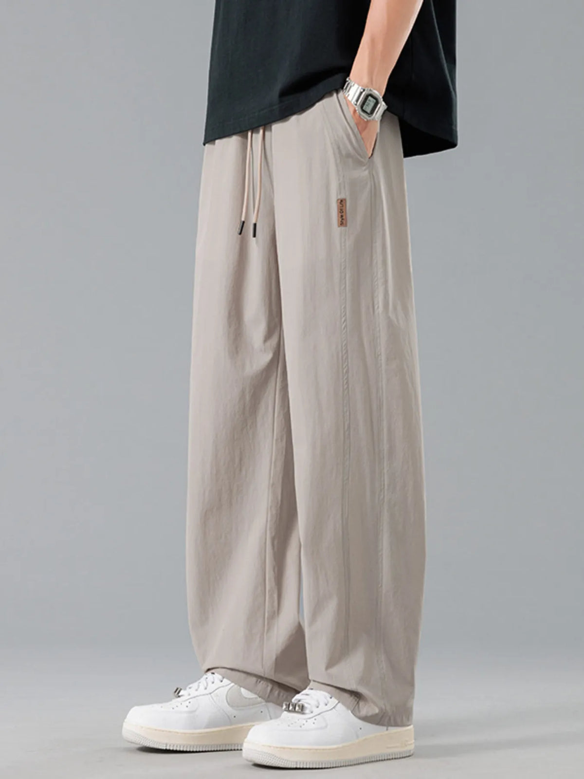Men's khaki loose-fit casual pants with a drawstring waist and pockets.