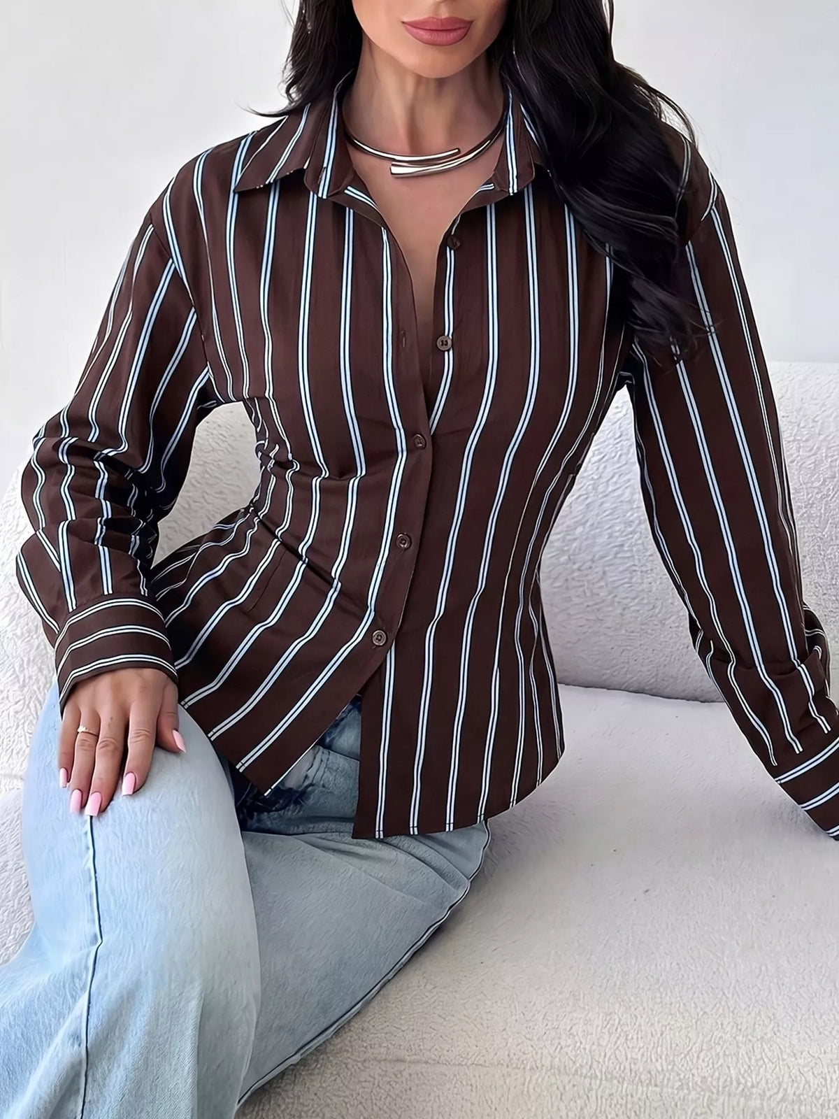 Seated front view of chocolate striped button down shirt with white stripes and long sleeves