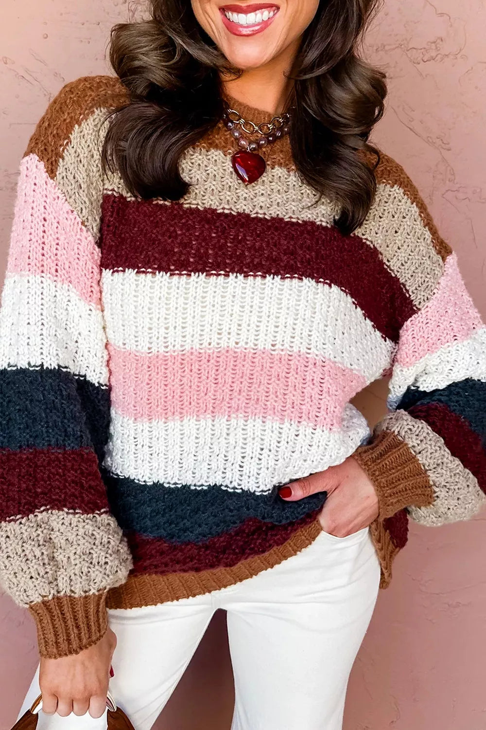 Front view of multicolor striped knit sweater with hand in pocket and ribbed cuffs