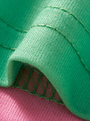 Close-up of the green hem and stitching at the edge of the pink t-shirt
