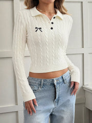White cable knit long sleeve sweater with polo collar, black buttons and small bow embroidery