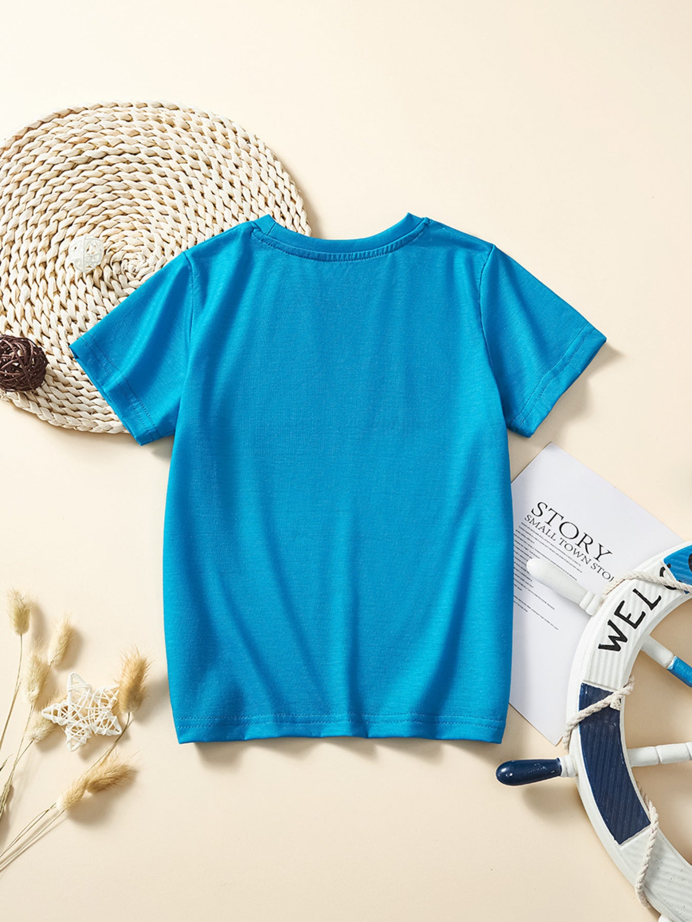 Back view of the plain sky blue children's short sleeve tee laid flat